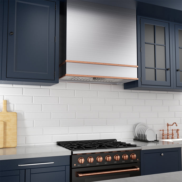 Modern kitchen with dark blue cabinets, white tiled wall, and black stove with copper accents.