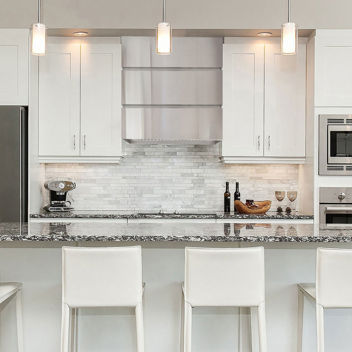 Modern kitchen with white cabinets, marble countertop, and stainless steel appliances.