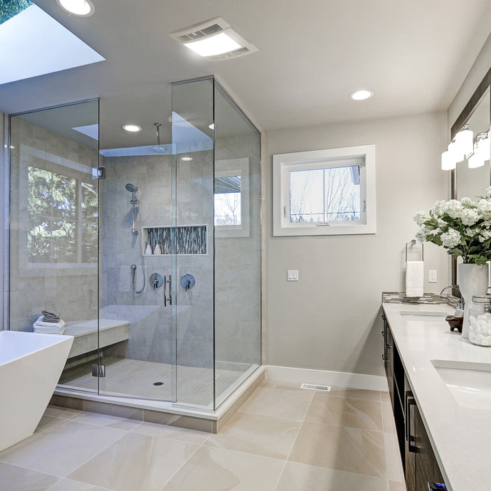 Modern bathroom with glass shower enclosure, bathtub, and vanity area.