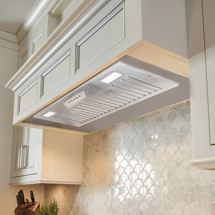 Kitchen hood installed above a tiled backsplash with decorative patterns