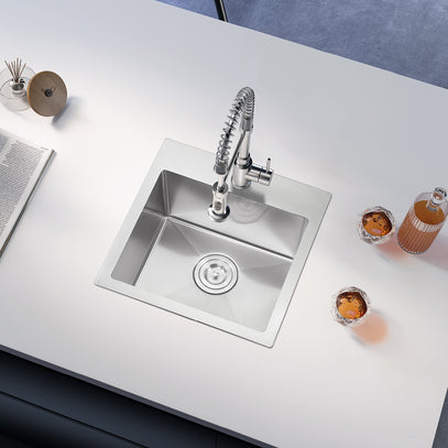 Stainless steel kitchen sink with faucet on a white countertop