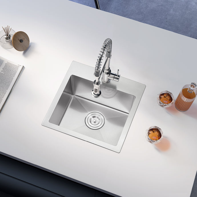 Stainless steel kitchen sink with faucet on a white countertop