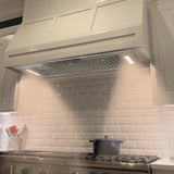 Kitchen with a range hood and tiled backsplash