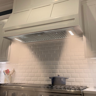 Kitchen with a range hood and tiled backsplash