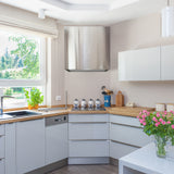 Modern kitchen with white cabinets, wooden countertops, and a window view.