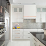 Modern kitchen with white cabinets, black countertops, and stainless steel appliances.