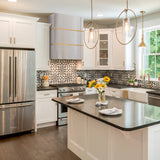 Modern kitchen with stainless steel appliances, white cabinets, and a black countertop.