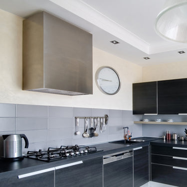 Modern kitchen with black countertops, stainless steel appliances, and a clock on the wall.