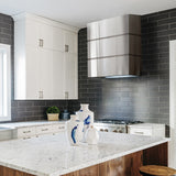 Modern kitchen with marble countertops, stainless steel appliances, and black tiled walls.