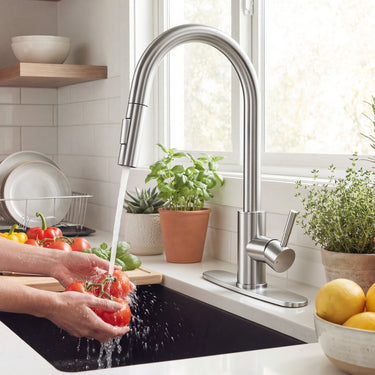 Person washing vegetables in a kitchen sink with a modern faucet.