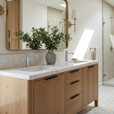 Bathroom vanity with wooden cabinets, marble countertop, and decorative plant.
