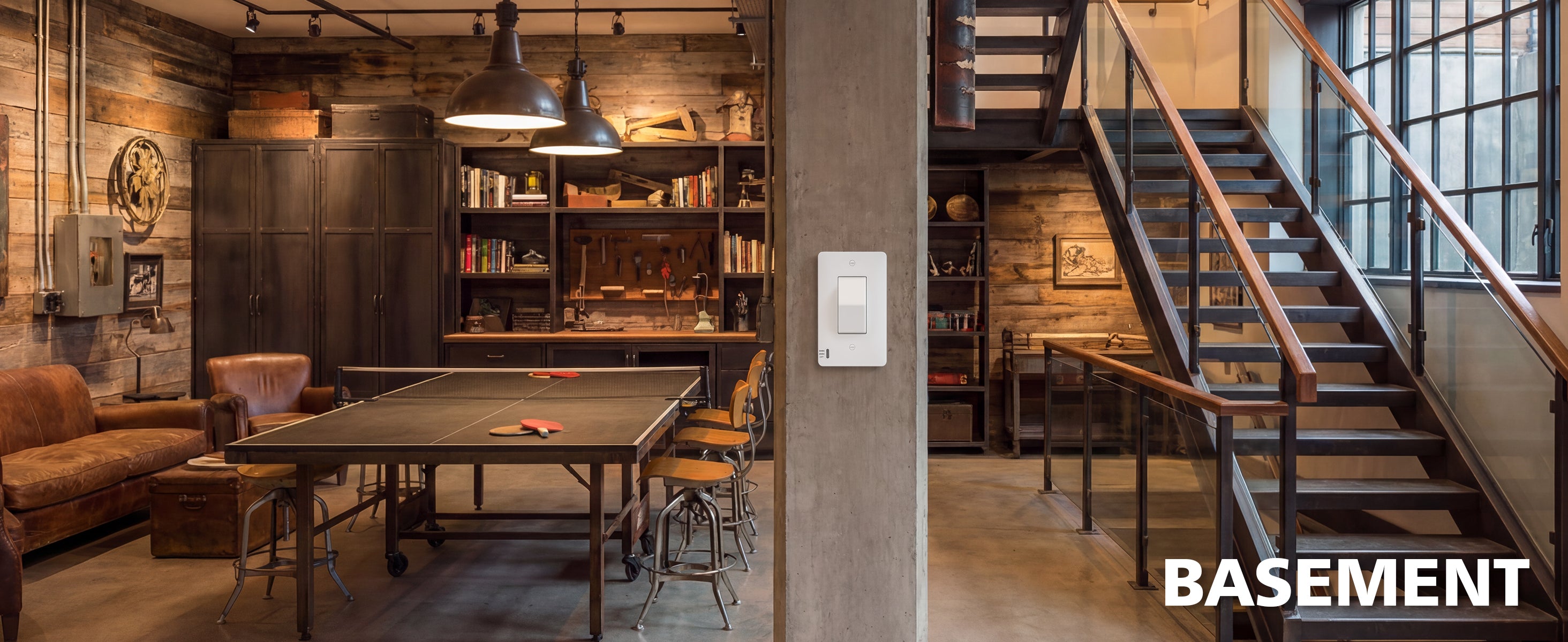 Indoors view of a basement with a pool table, bookshelves, and a staircase.