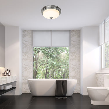 Modern bathroom with a freestanding bathtub, toilet, and large window overlooking trees.
