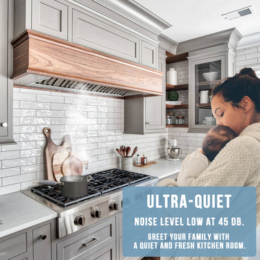 Woman holding a baby in a modern kitchen with text about ultra-quiet noise level