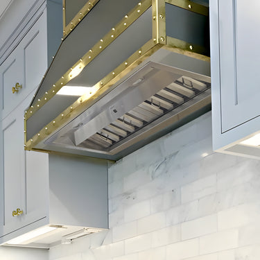 Modern kitchen hood with gold accents in a white kitchen setting