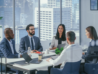 Group of professionals in a meeting room with cityscape view