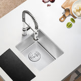 Stainless steel kitchen sink with a modern faucet on a white countertop.
