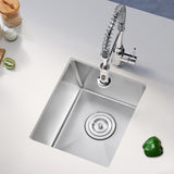 Stainless steel kitchen sink with a faucet on a white countertop.