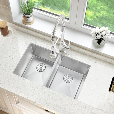 Stainless steel kitchen sink with faucet on a light-colored countertop.